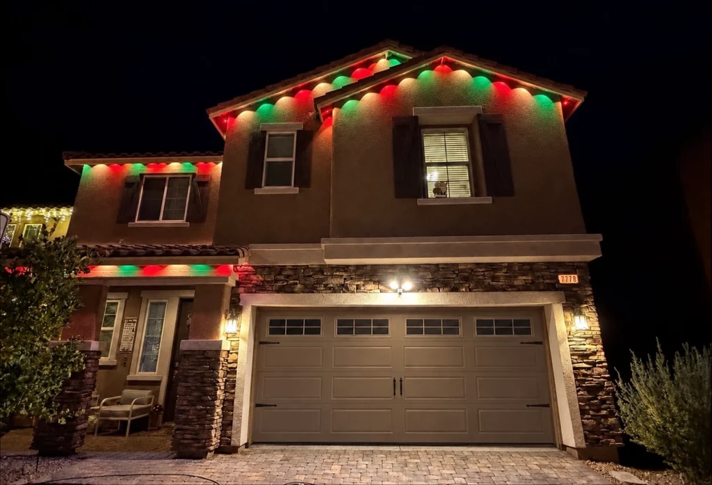 Color-changing permanent roofline lights illuminating a home at night.